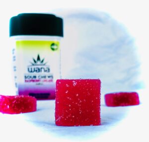 detail of wana sour chew in foreground with other chews in the background with Wana bottle